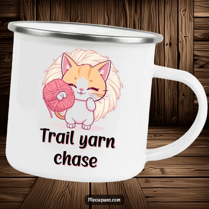Funny camping mug with a playful cat batting a giant, fuzzy yarn pom-pom, ideal for outdoor fun and laughter.