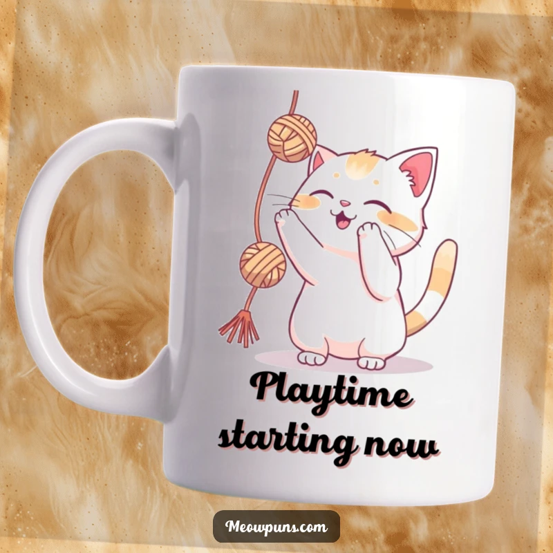 Funny cat playfully swatting at a bright yarn ball on a mug, celebrating feline energy and joy.