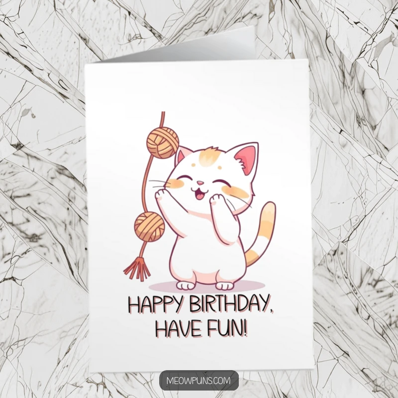 Funny Free Printable Birthday Card: A cat gleefully batting at a dangling ball of yarn with its paws.